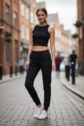 Black jogger sweatpants on petite woman - full body fit with sneakers and crop top