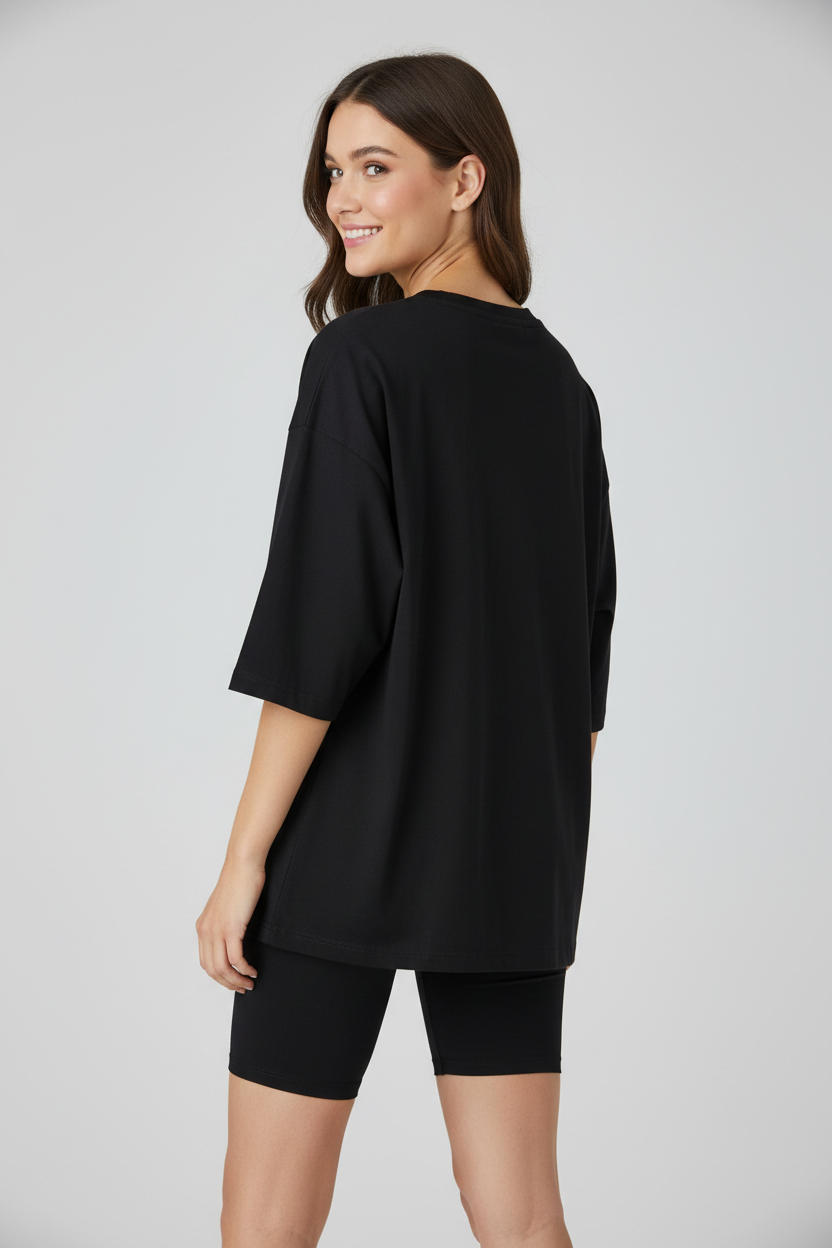 Black oversized t-shirt - back view with woman looking over shoulder, feminine silhouette