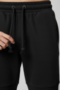 Black jogger pants waistband detail - elastic drawstring and ribbed ankle cuffs close-up